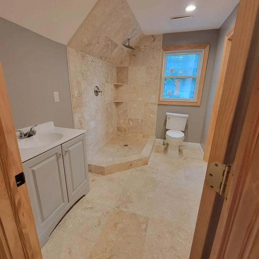 Boonton attic bathroom with tiled shower, vanity, and toilet