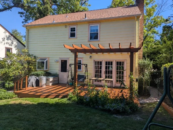 West Orange backyard with refinished wood deck, railings, pergola, and garden beds